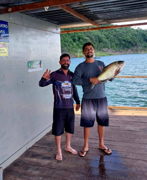 Dupla de pescadores com troféu no tablado